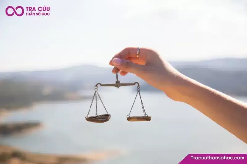 Người đang cố gắng cân bằng những viên đá bên bờ biển, tượng trưng cho việc giữ vững tinh thần trước khó khăn